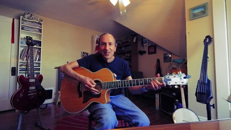 Photo of Bobby Fisher teaching a video on chord construction on guitar for suspended chords.