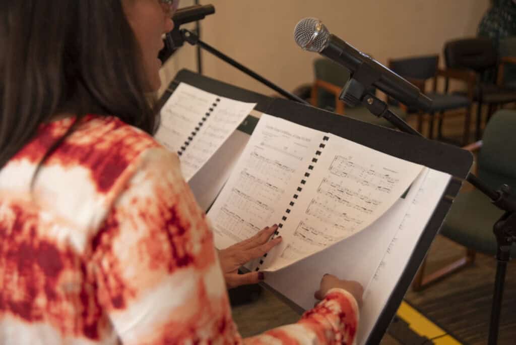 Photo of music on a stand and microphone to represent leadership styles in music ministry