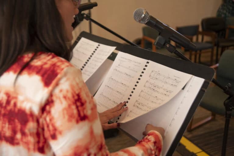 Photo of music on a stand and microphone to represent leadership styles in music ministry