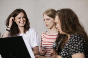 Three young people rehearsing to represent engaging youth in music ministry.