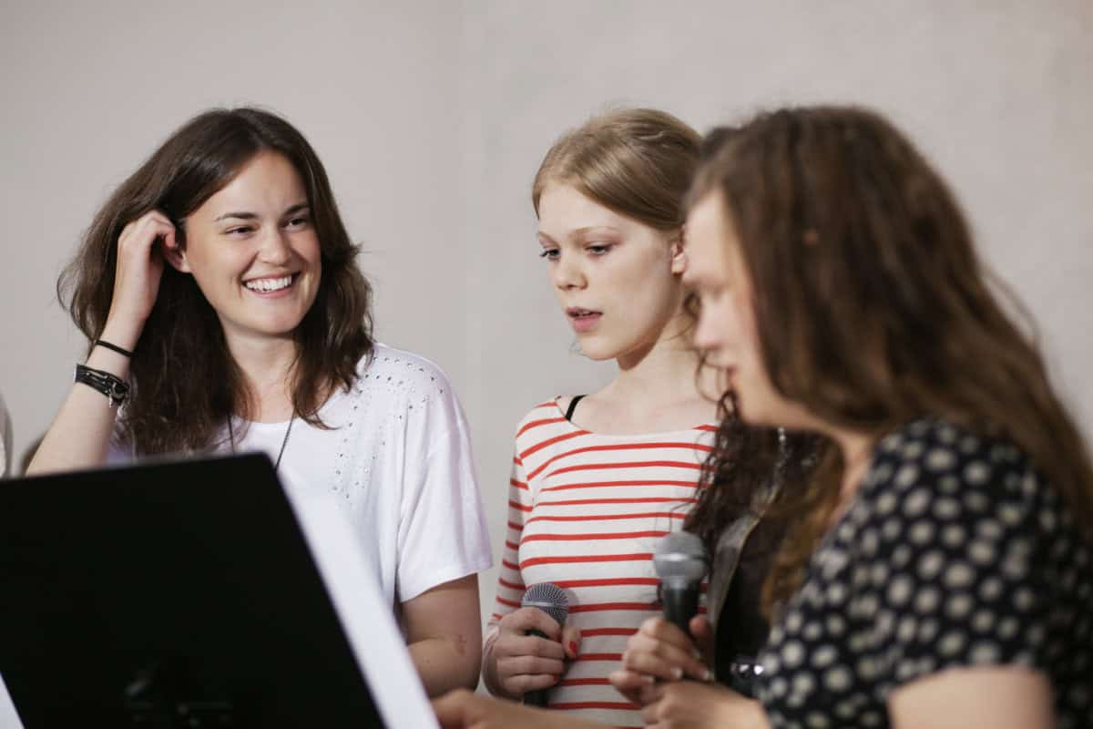 Three young people rehearsing to represent engaging youth in music ministry.