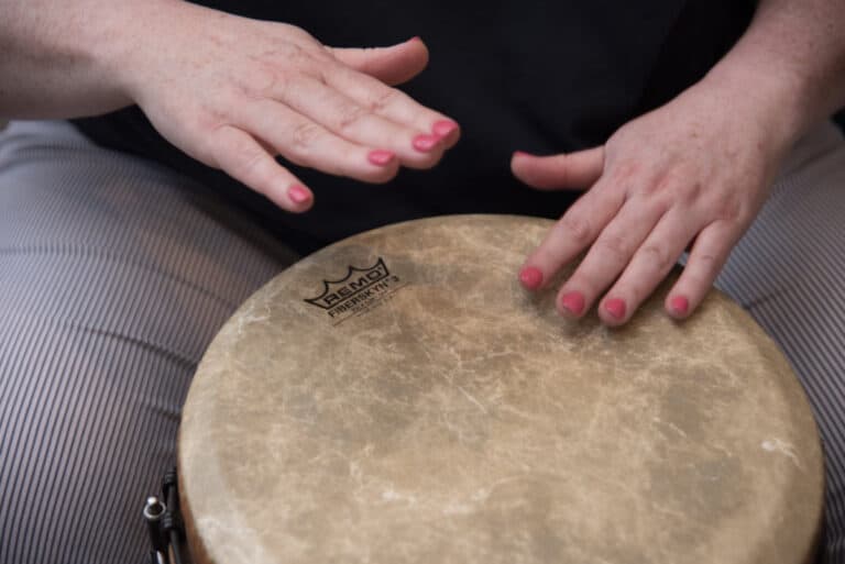 Photo of a woman playing a hand drum to illustrate tips for ensemble musicians