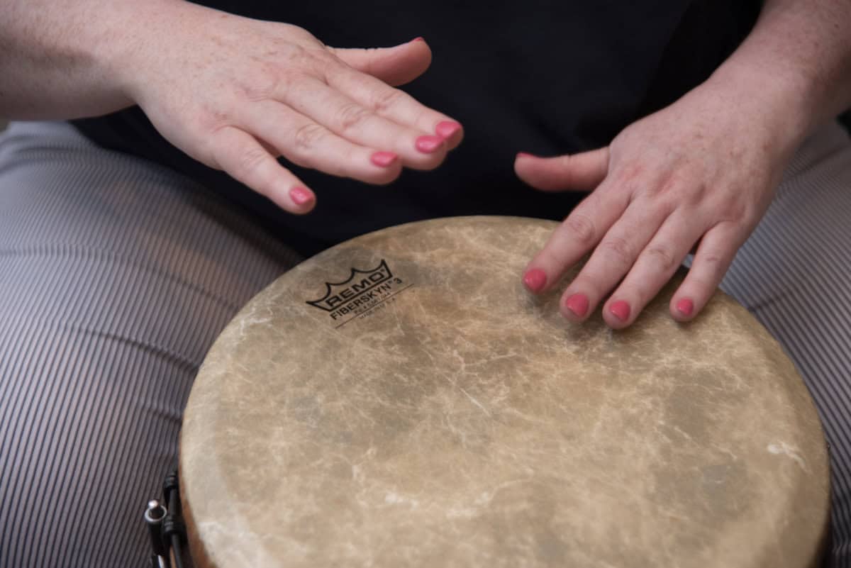 Photo of a woman playing a hand drum to illustrate tips for ensemble musicians