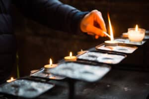 Person lighting a candle to commemorate All Souls Day
