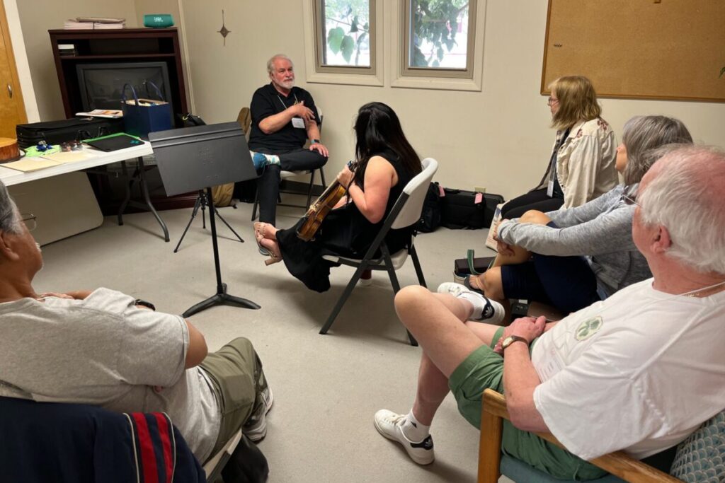 Small group coaching session at a CLEF workshop where musicians explore liturgical music using Catholic music resources and shared ministry resources.