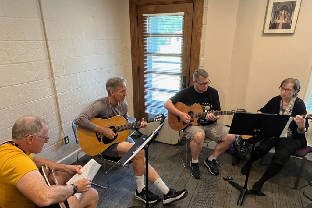 Ensemble musicians rehearsing together using Catholic music resources and ministry resources to strengthen liturgical music in parish life