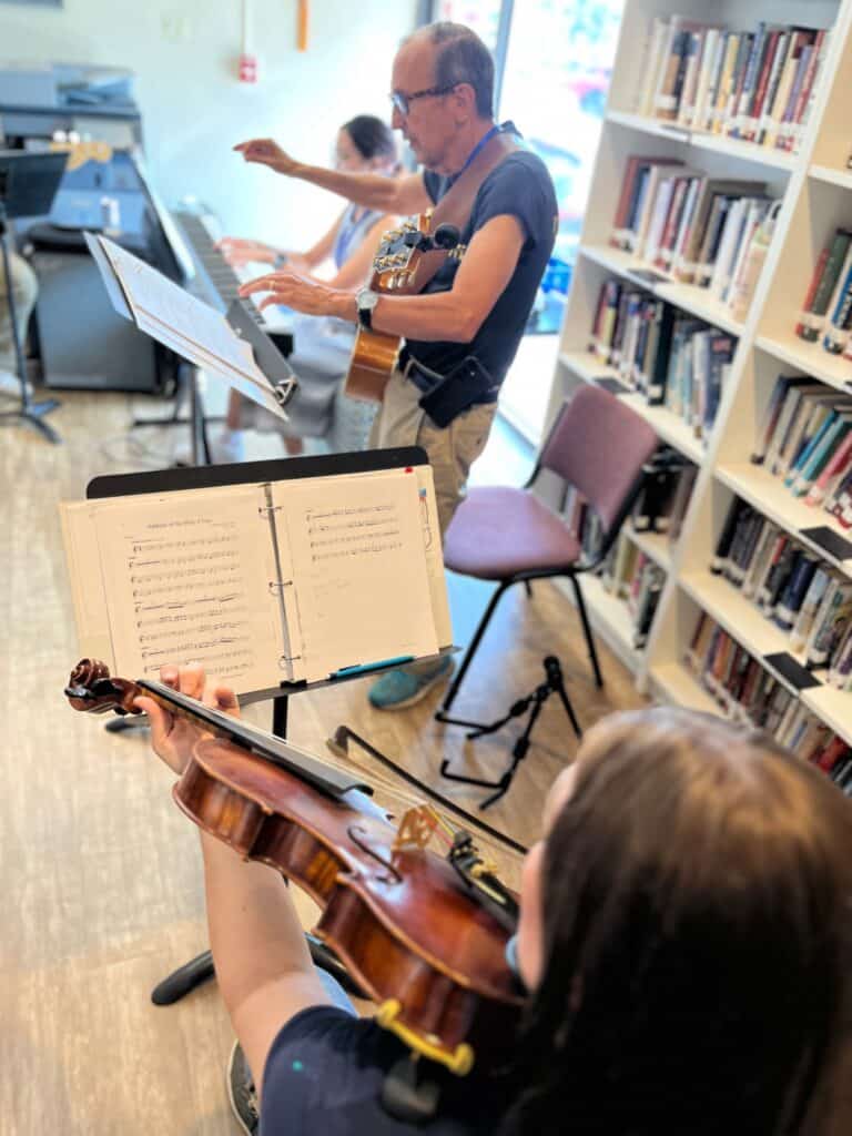 Ensemble musicians rehearse liturgical music using Catholic music resources during a CLEF workshop focused on ministry resources and collaborative ensemble skills.