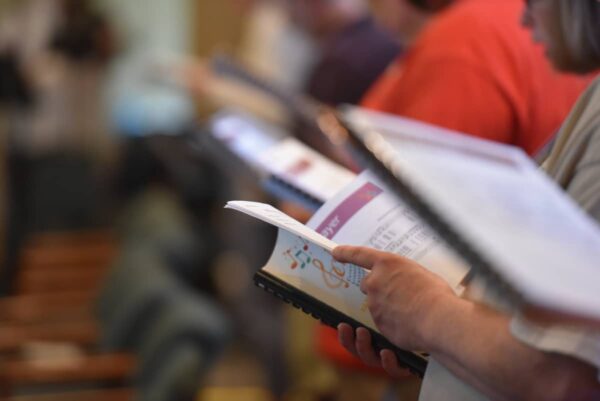 Ensemble musicians reading music together during a liturgical music conference