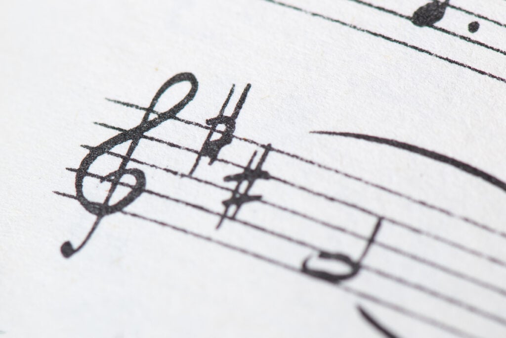 Photo of treble clef with two sharps and the beginning notes of music to illustrate music theory basics