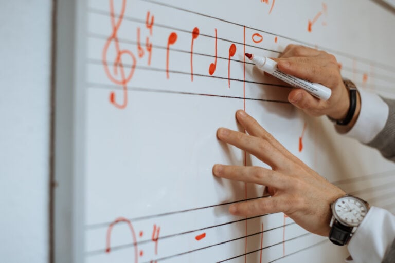 Photo of a person teaching music theory on a whiteboard