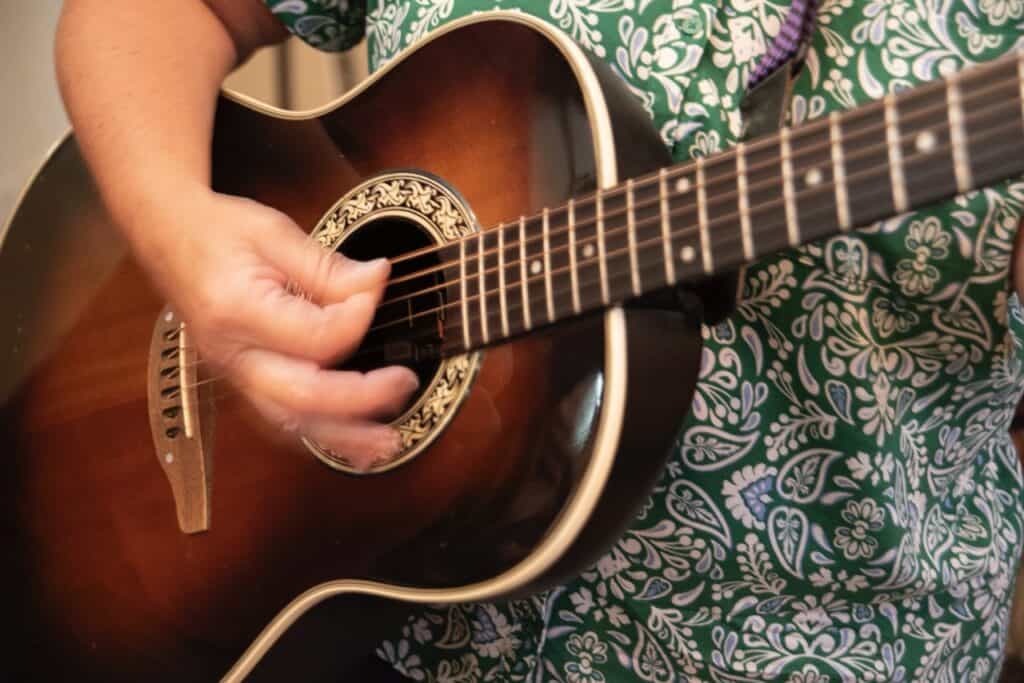 Photo of a woman playing guitar to accompany article on chord theory