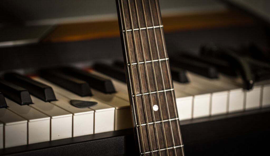 photo of piano keys and a guitar fretboard to illustrate chord theory and 7th chords