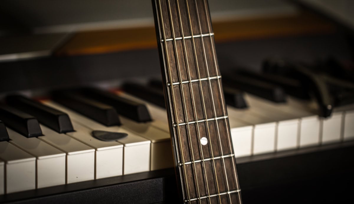 photo of piano keys and a guitar fretboard to illustrate chord theory and 7th chords