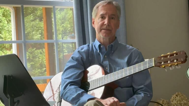 Photo of Steve Petrunak with a guitar teaching vocal drills for good diction