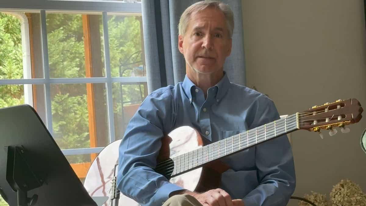 Photo of Steve Petrunak with a guitar teaching vocal drills for good diction